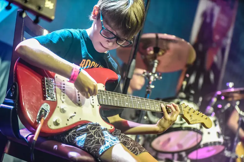 Aluno tocando guitarra